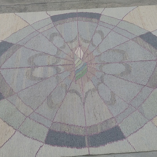 Detailed tactile video of the oversized tapestry rug, showing the beautiful soft contrast of the pastel pink and charcoal geometric arcs in the authentic handwoven 80s flatweave wool carpet.