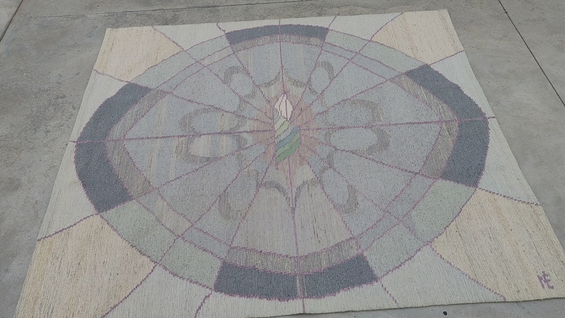 Detailed tactile video of the oversized tapestry rug, showing the beautiful soft contrast of the pastel pink and charcoal geometric arcs in the authentic handwoven 80s flatweave wool carpet.