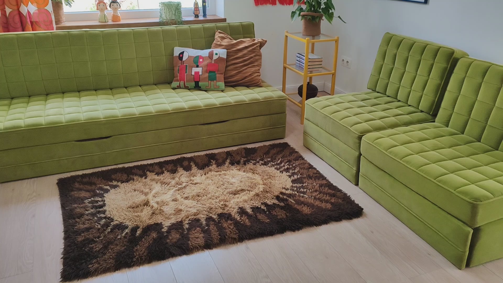 Video of a vintage 70s rya style shag rug with sunburst design in brown, caramel and cream, showing how the thick, soft pile feels and moves when touched