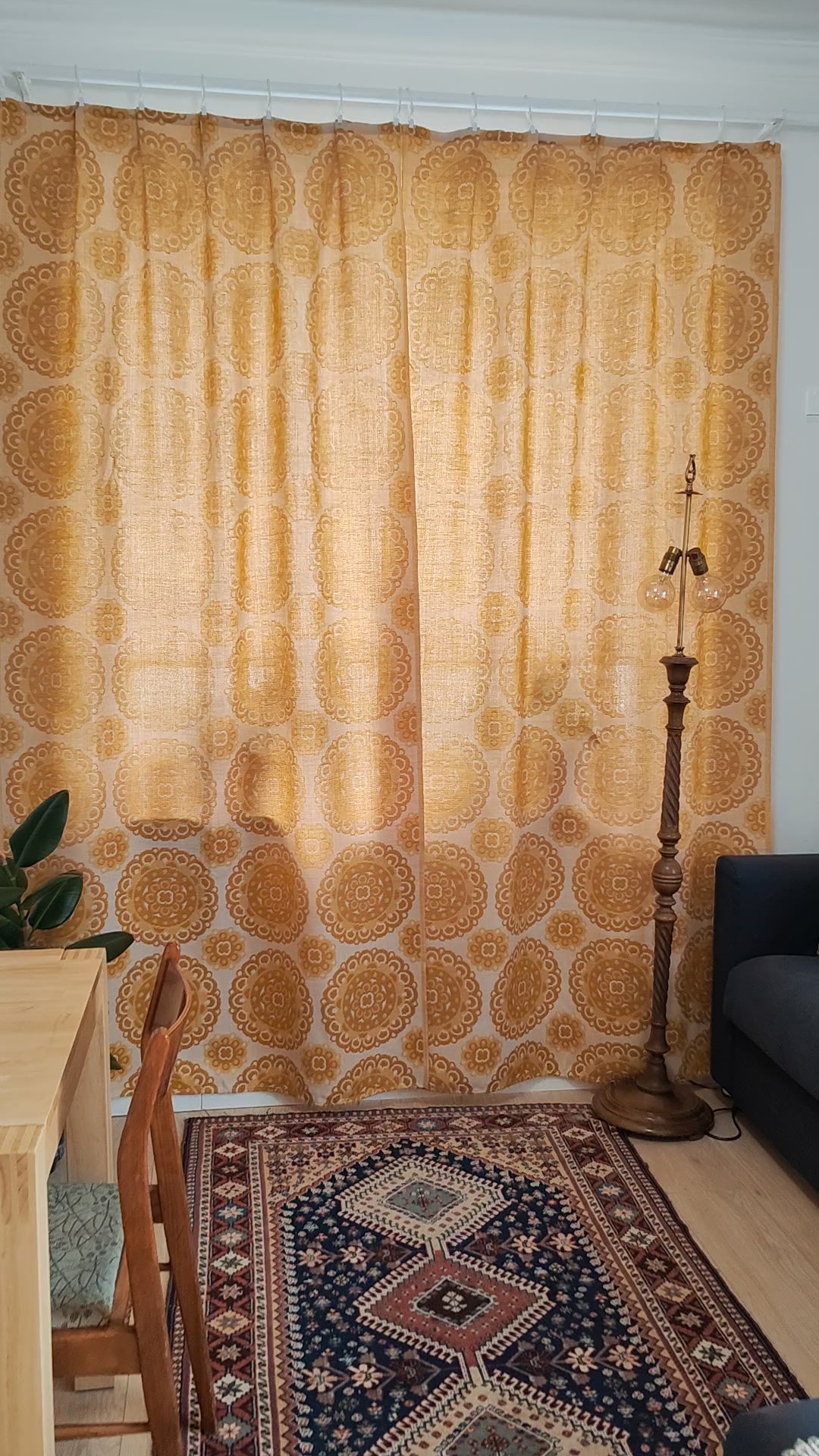 Video of a 70s vintage mustard yellow jacquard curtain pair with woven medallion pattern, showing the full length curtains hanging at a window and close-ups of the reversible textured fabric.