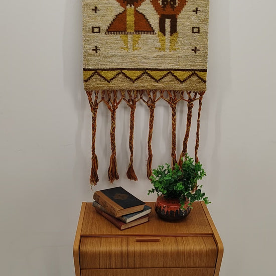 A video panning over a vintage mid-century Hungarian tapestry, then moving to a hand gently holding and moving the fabric to showcase the incredible organic thickness, warm earth tones, and beautifully draped textile structure.