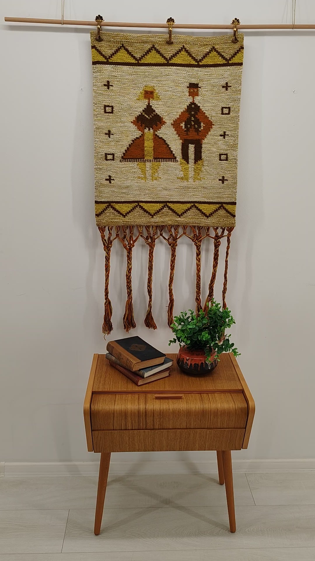 A video panning over a vintage mid-century Hungarian tapestry, then moving to a hand gently holding and moving the fabric to showcase the incredible organic thickness, warm earth tones, and beautifully draped textile structure.