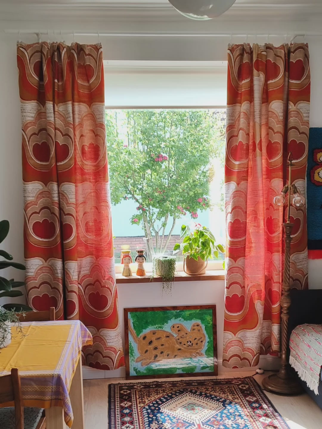 Pair of 1970s vintage curtains with bold Flower Power pattern hanging at a window in a retro style living room, also showing the texture of the high quality jacquard drape.