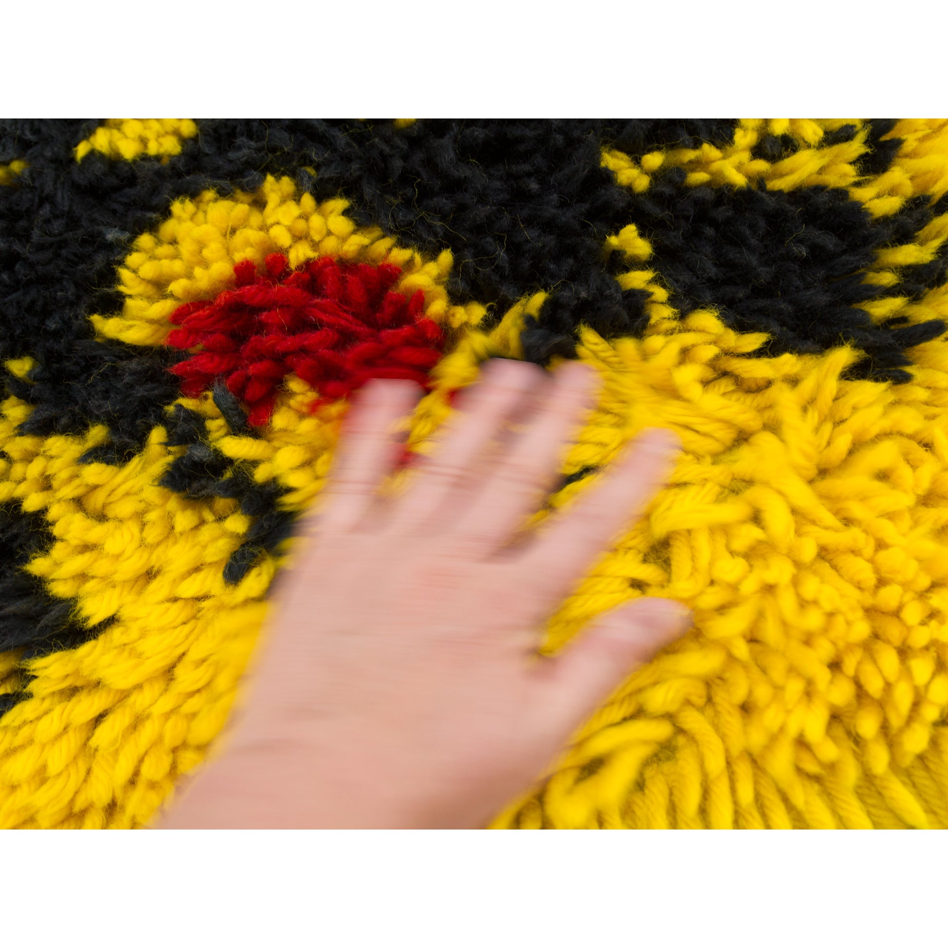 Tactile video of the yellow and black vintage shag tapestry styled as an accent floor rug in a mid century room setting, showing scale and vibrant colors.