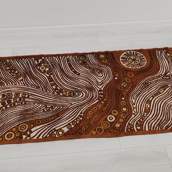Full view and macro detail video of the authentic 1960s mid century modern tapestry. The retro op-art design mimics hypnotic woodgrain and abstract cellular suns in brown, mustard, and cream.