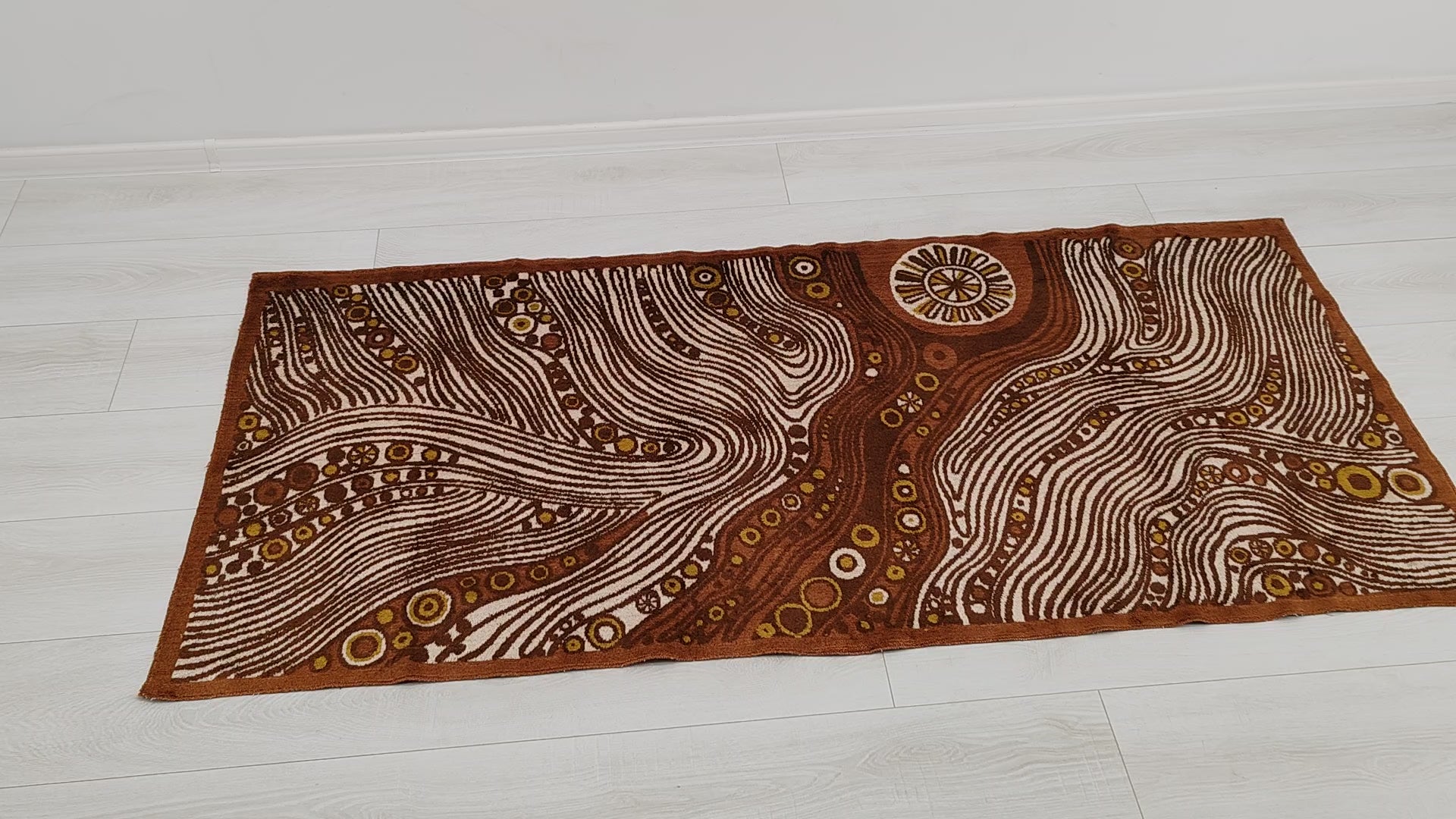 Full view and macro detail video of the authentic 1960s mid century modern tapestry. The retro op-art design mimics hypnotic woodgrain and abstract cellular suns in brown, mustard, and cream.