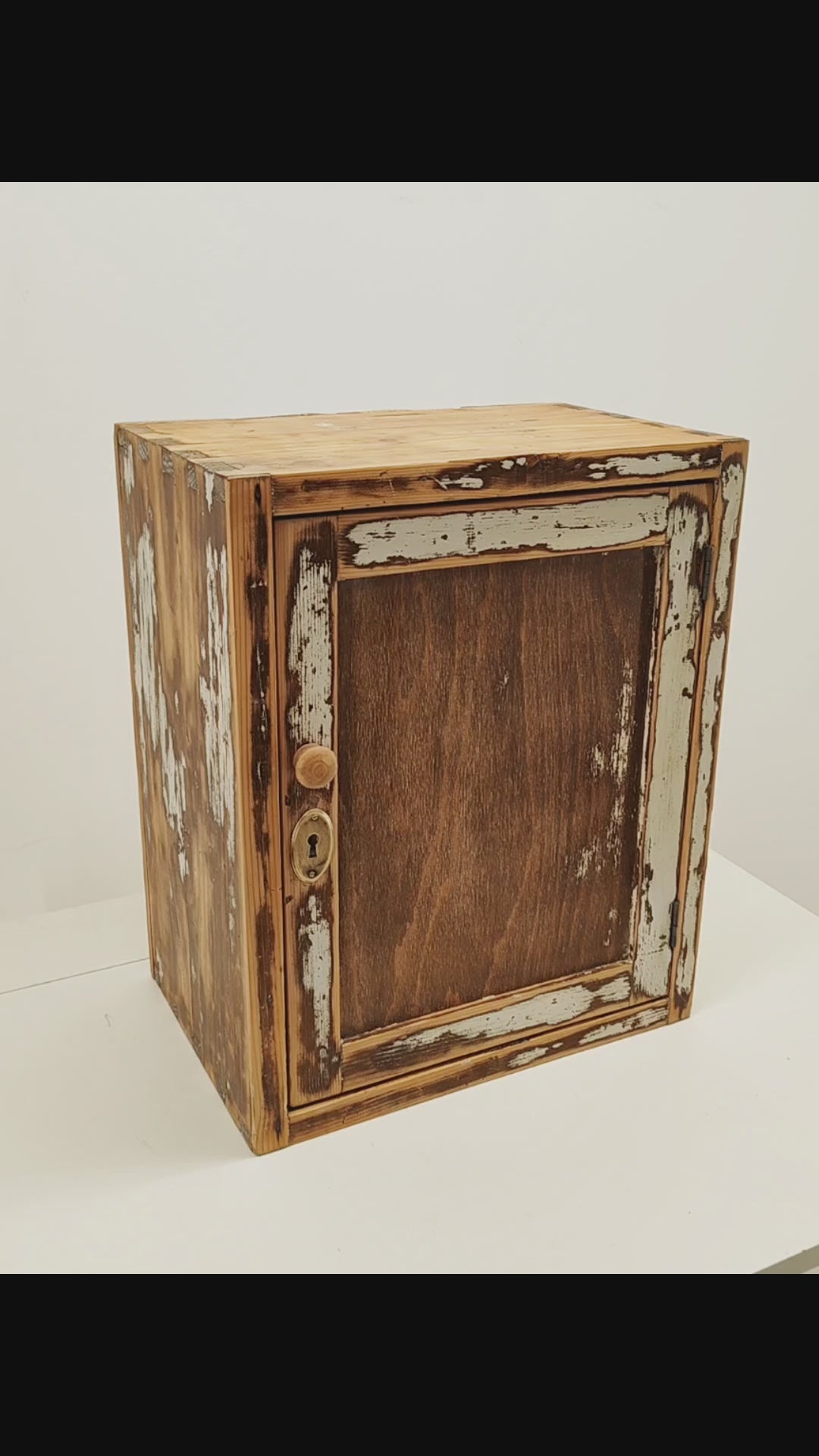 Video of a refurbished vintage solid pine wall cabinet with chippy white paint, showing the satin wax finish, the door opening and the removable shelf inside.