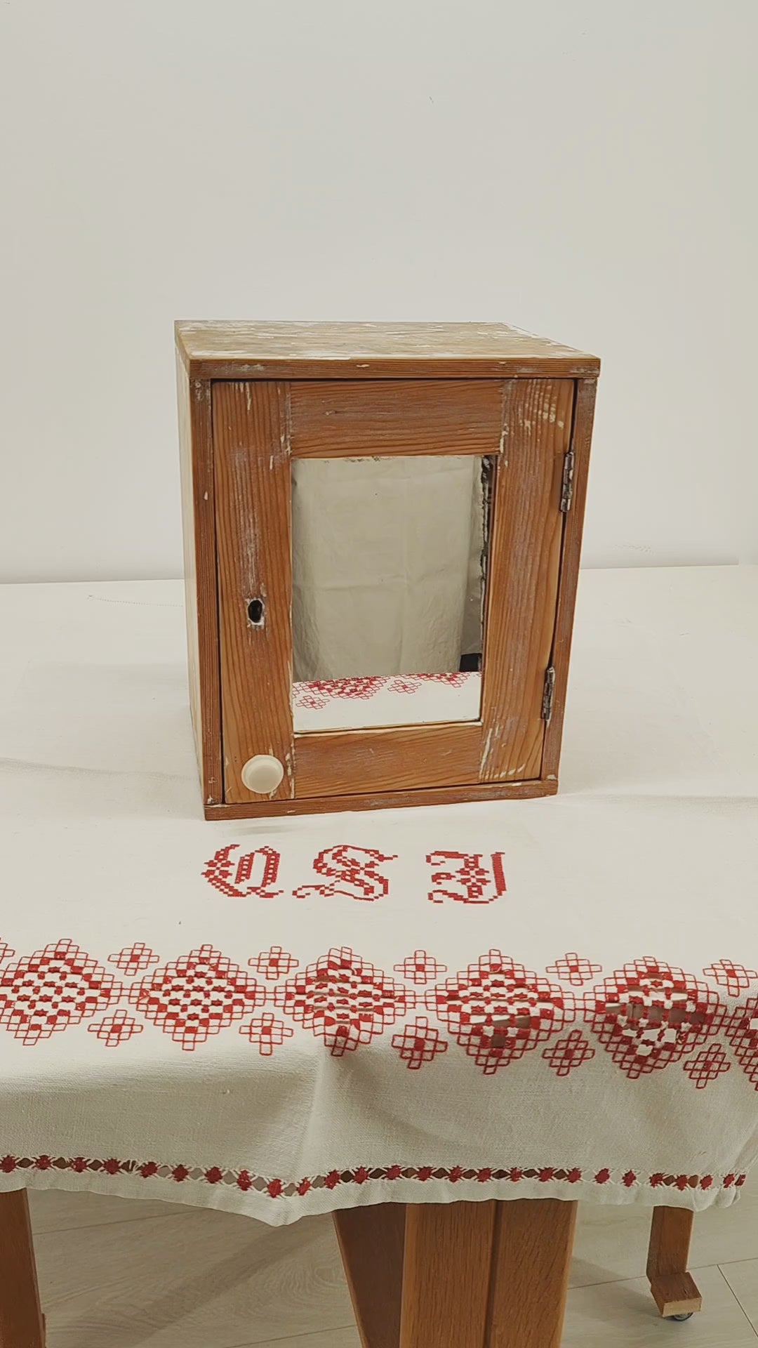 Video of a small vintage wooden wall cabinet or medicine cupboard with mirror door, showing the smooth satin wax finish, the original mirror, the door opening and the removable shelf inside