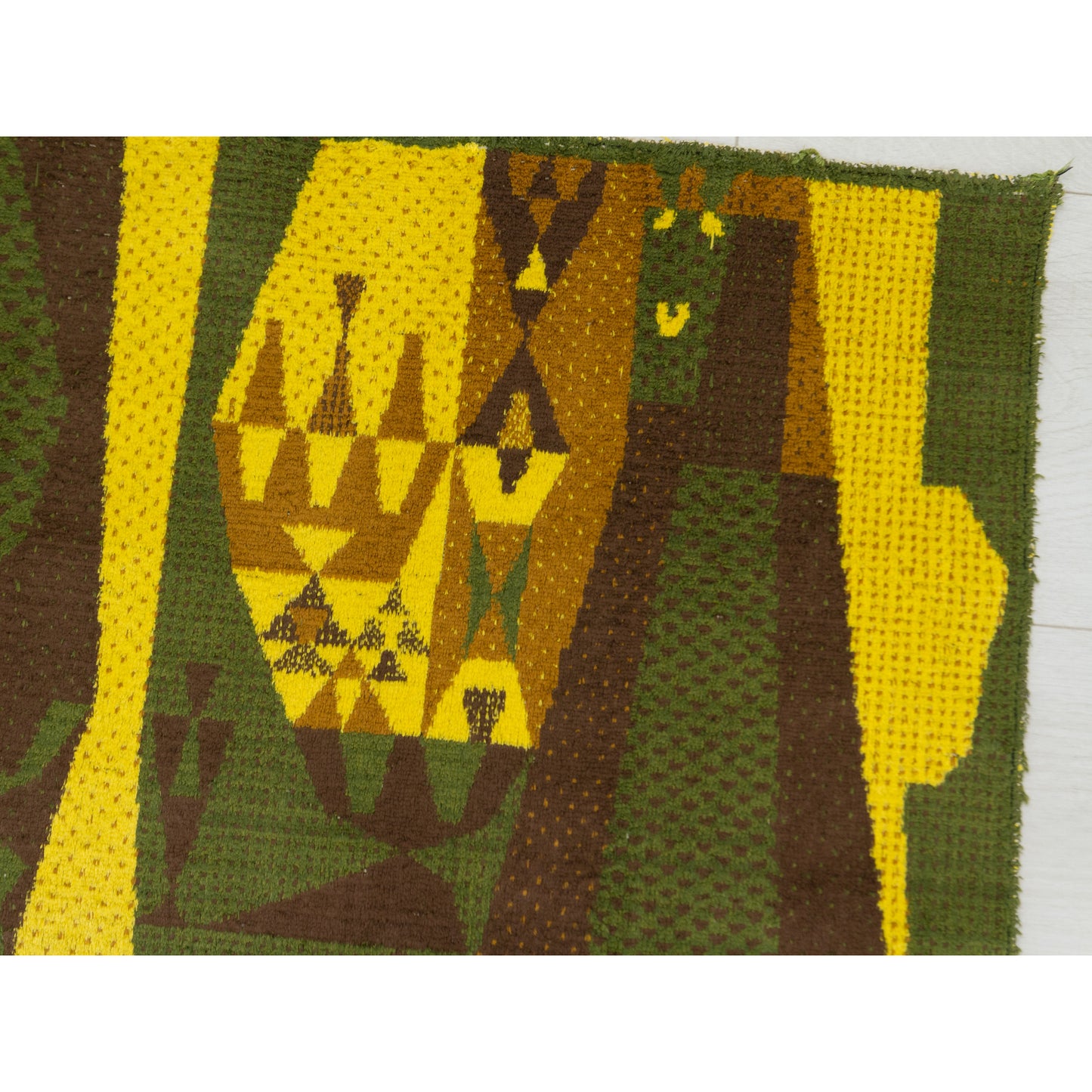Extreme close up of the trippy, abstract geometric design. High-contrast blocks of canary yellow against deep moss green and warm chocolate brown.