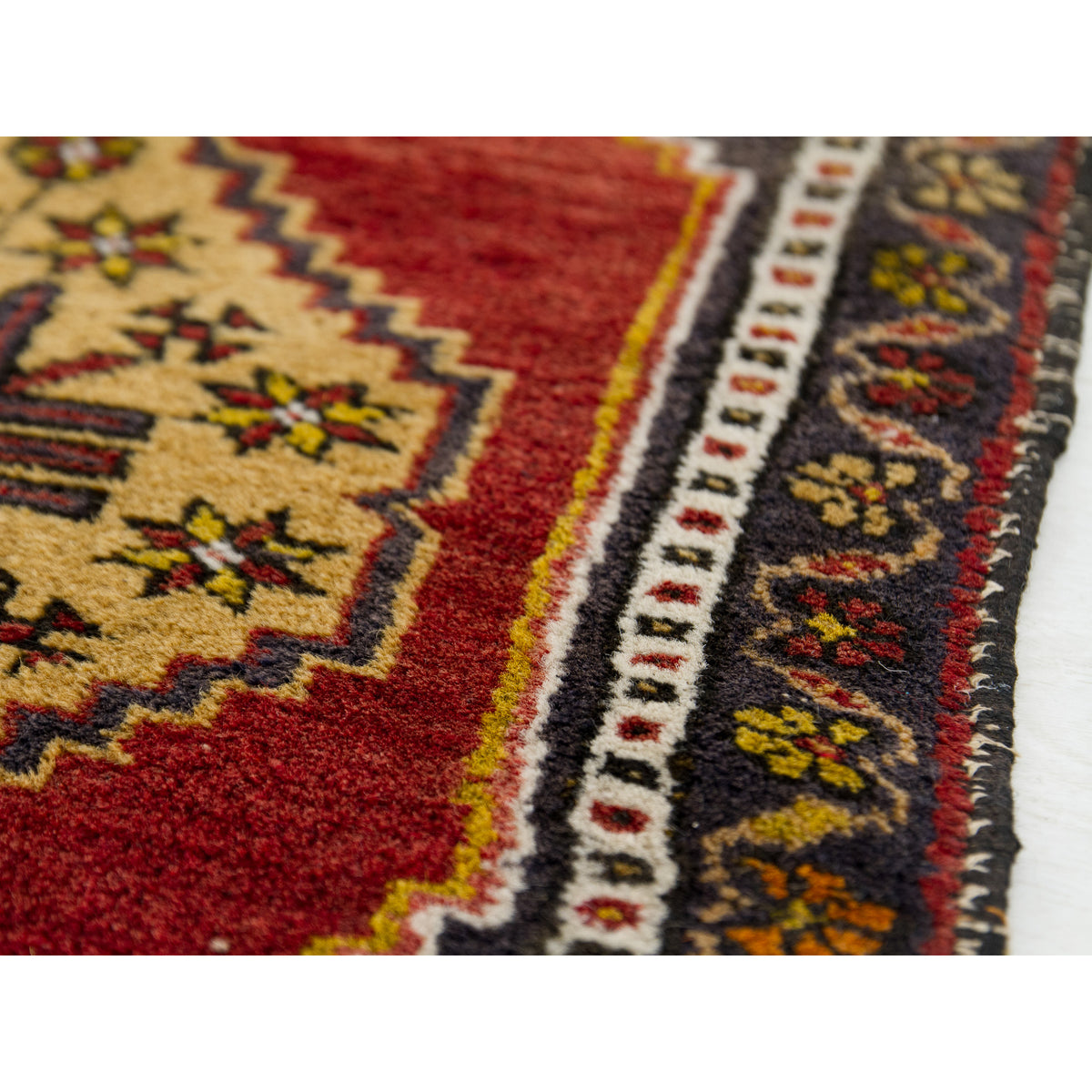 Detail of a red Turkish rug medallion with gold star flowers and soft wool pile