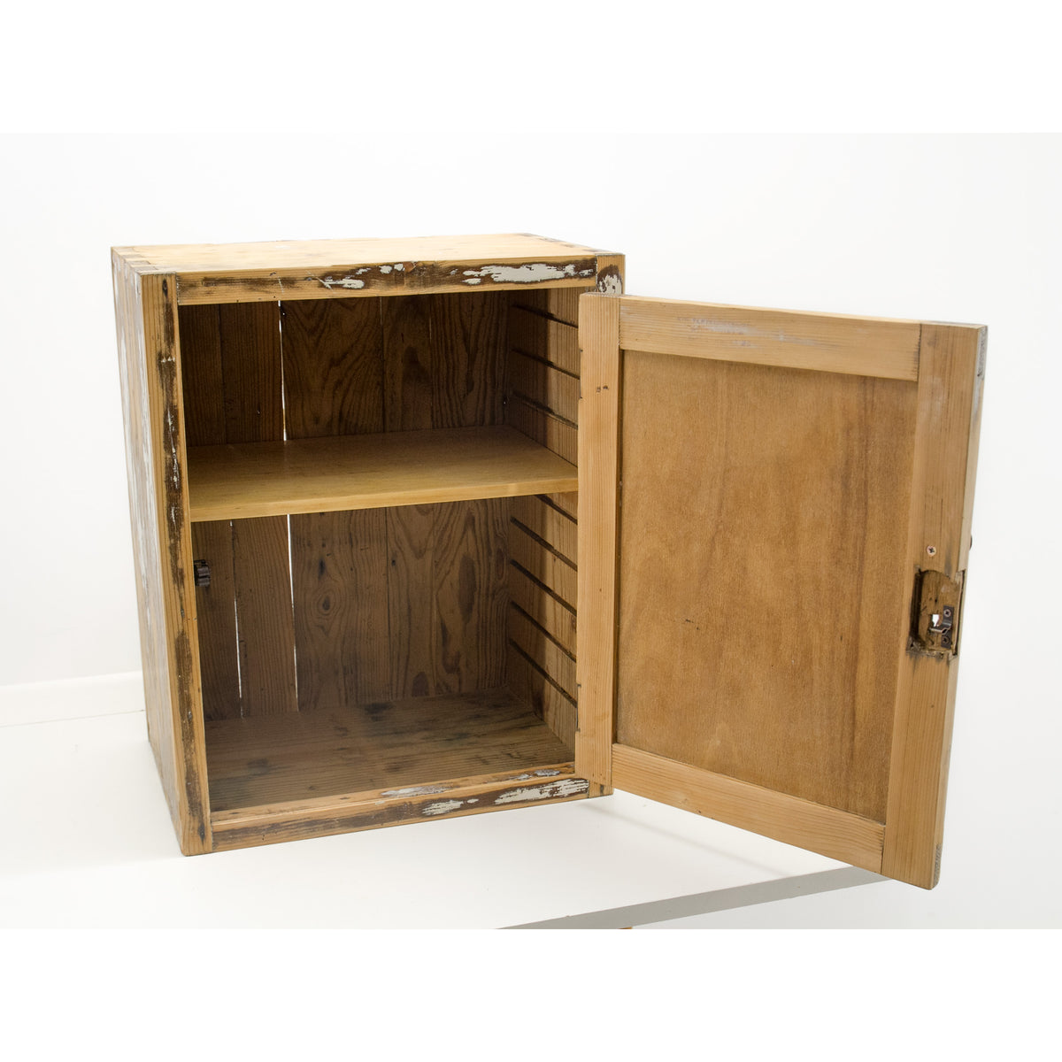 Refurbished vintage medicine cabinet with a single door swung open, showing a two-shelf interior. The cabinet has a natural light brown wood finish with visible distressing and time-worn chipped paint, set against a plain white background.
