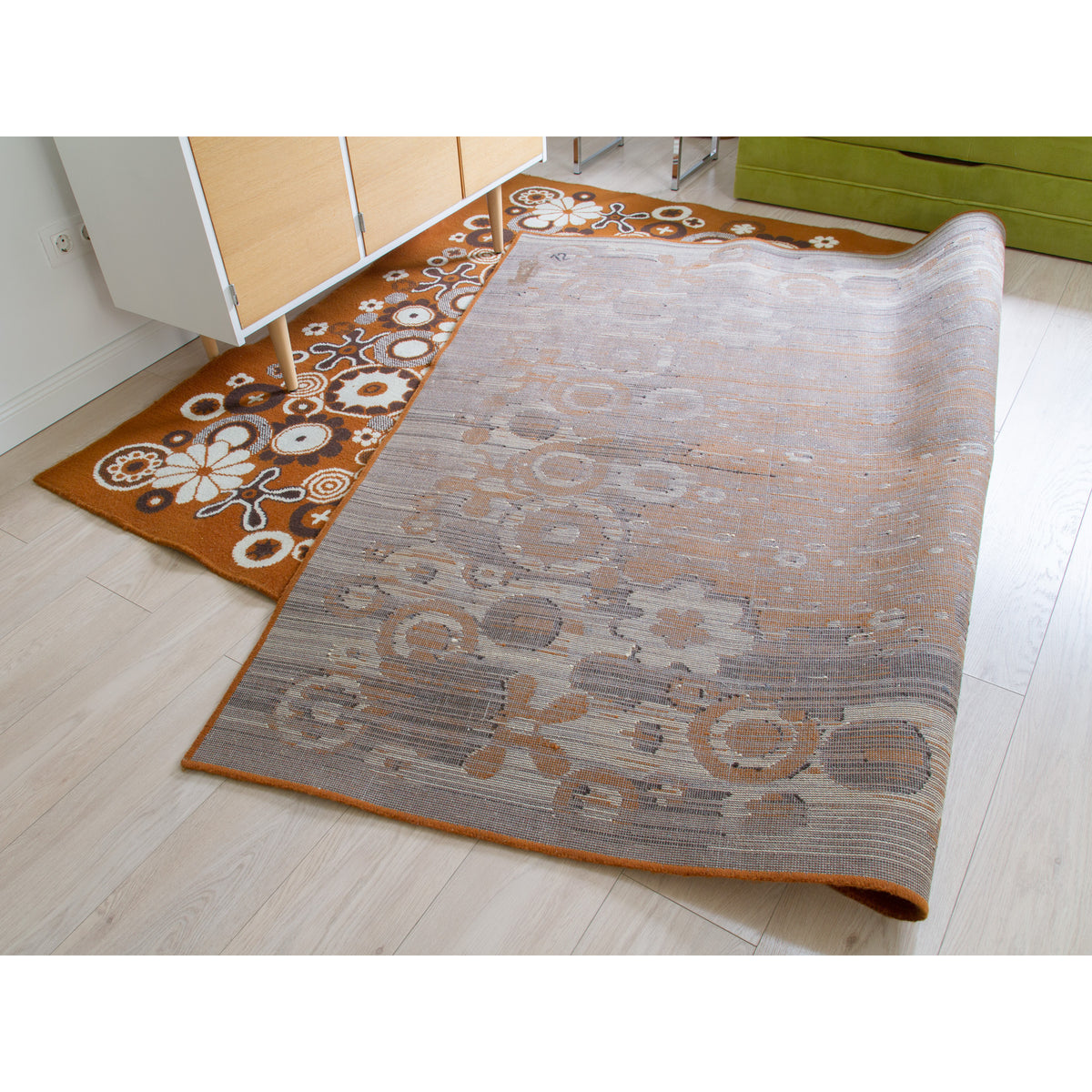 Retro area rug in a 70s style living room, partly folded to show the clean back side and overall excellent condition