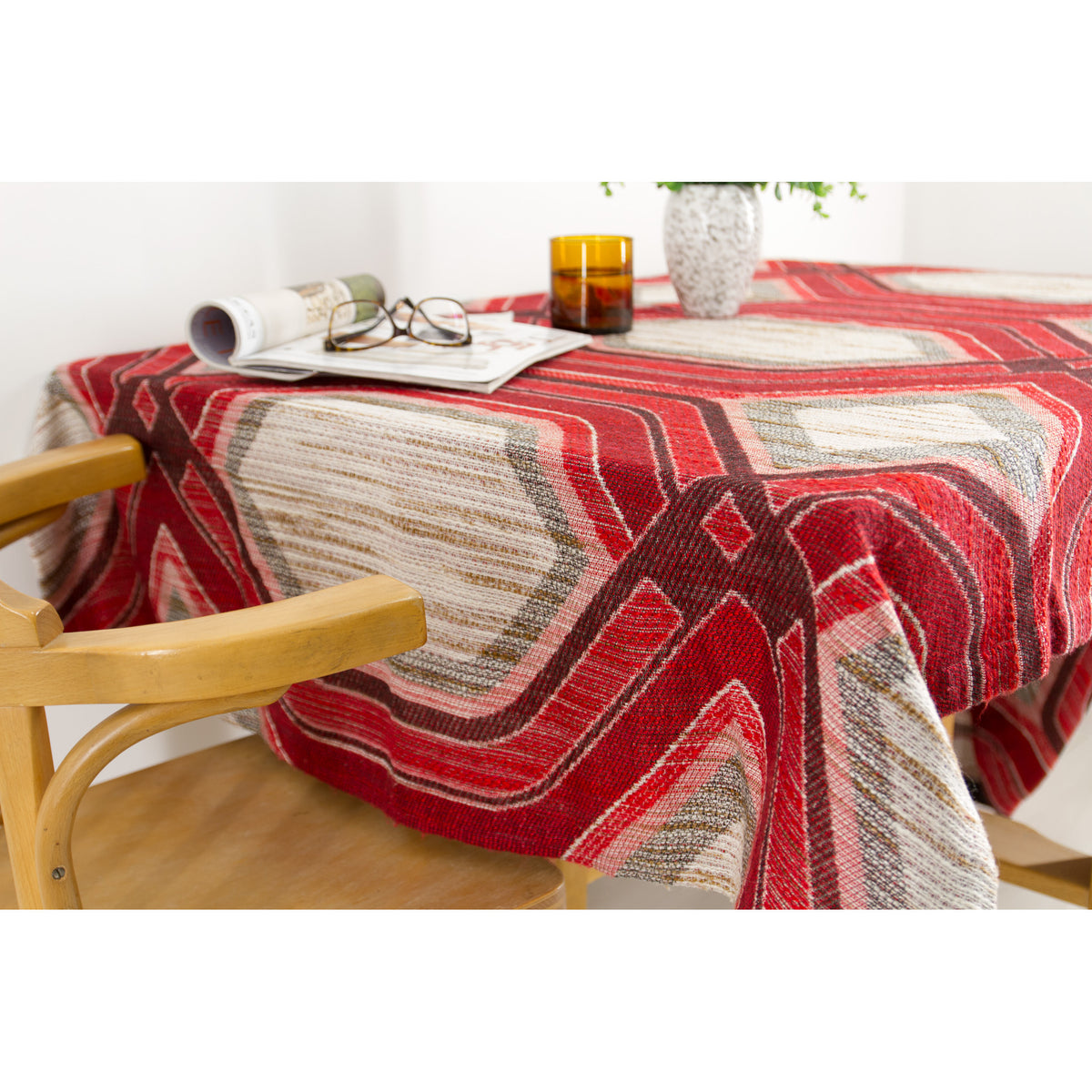 Retro red and grey op art tablecloth draped over a table with a mid century bentwood chair