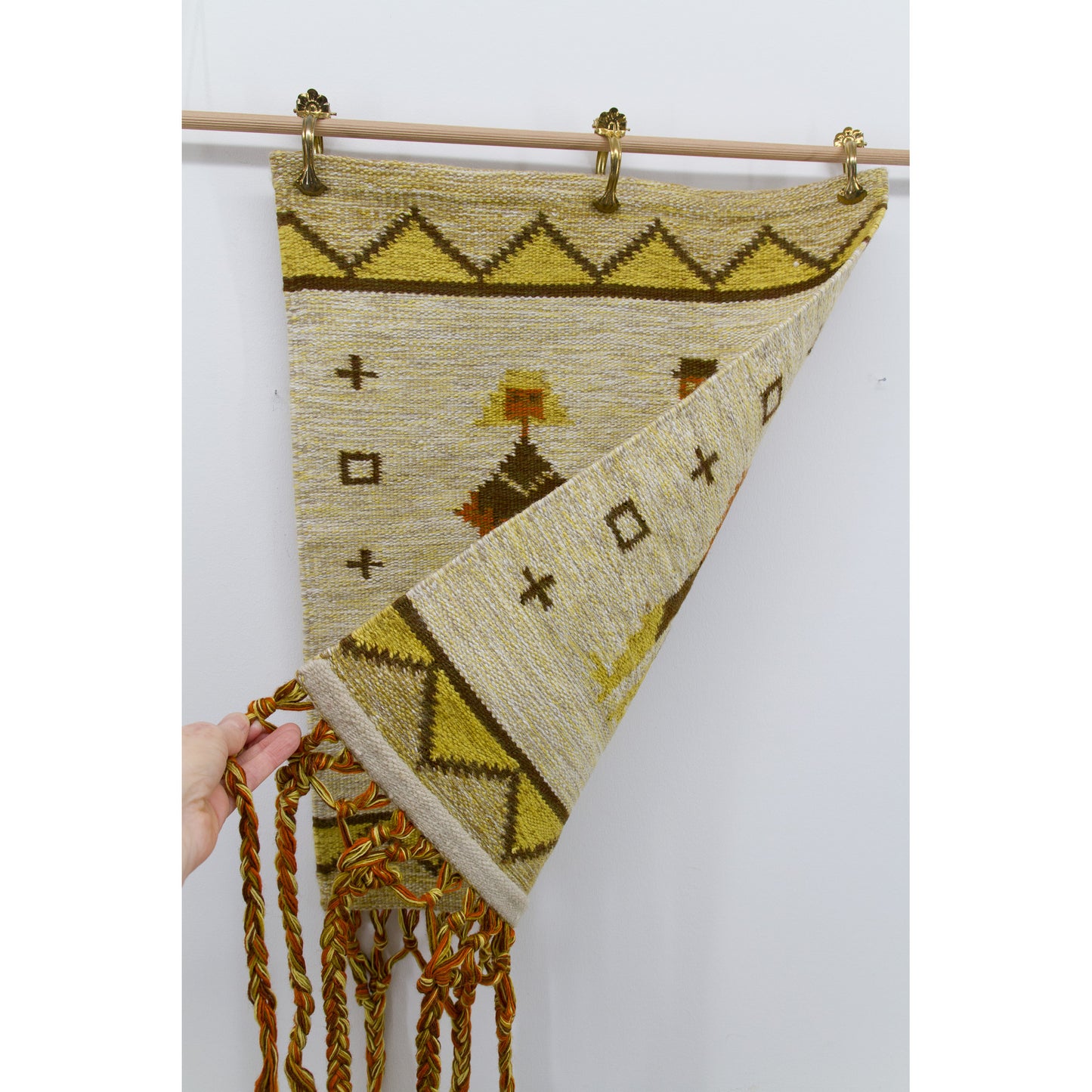 The edge of the mid century wall decor is lifted to reveal its perfectly clean and fully reversible backside, showing pristine preservation.