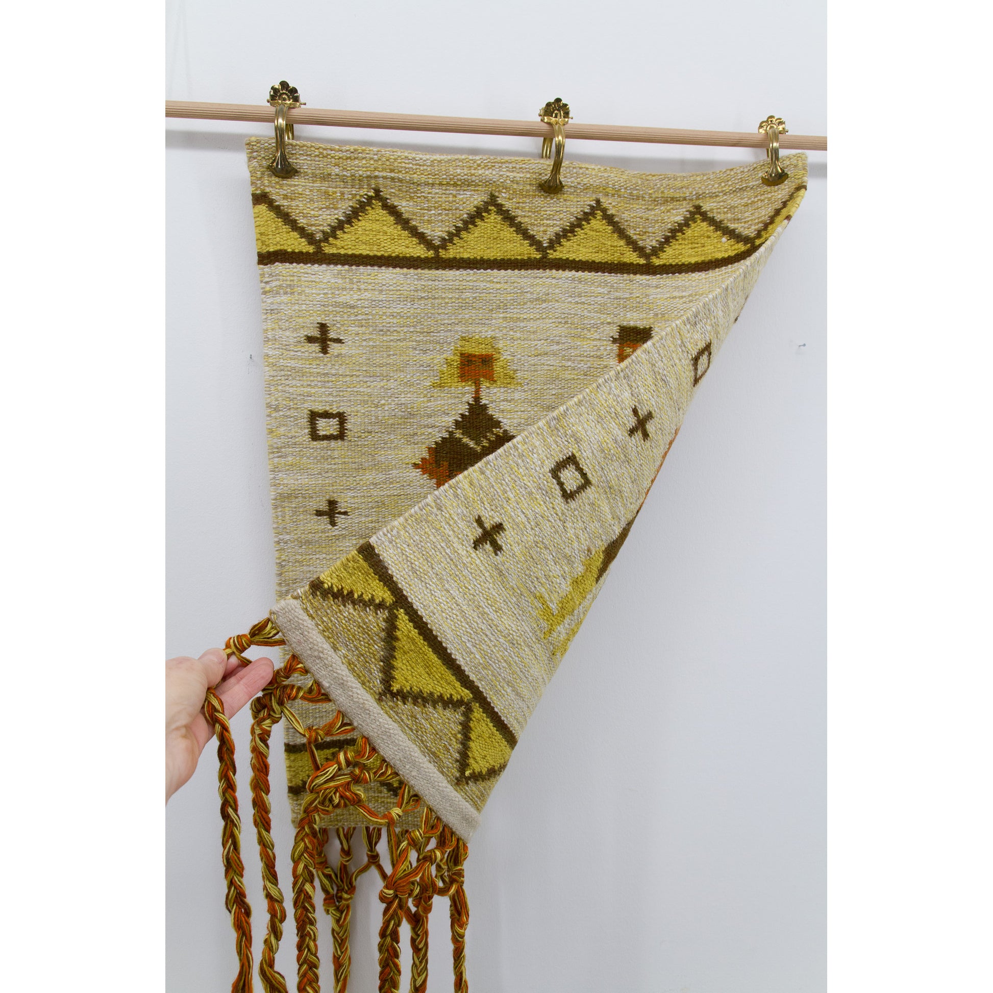 The edge of the mid century wall decor is lifted to reveal its perfectly clean and fully reversible backside, showing pristine preservation.