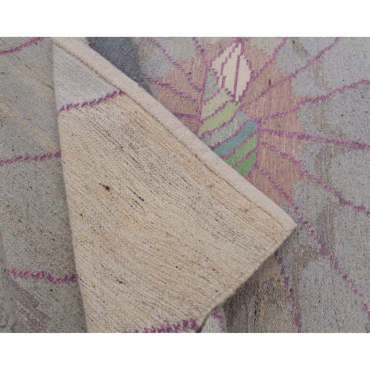 A corner of the rug elegantly folded over, showcasing the clean, masterfully woven reverse side. Fully reversible design typical of premium vintage flatweaves.