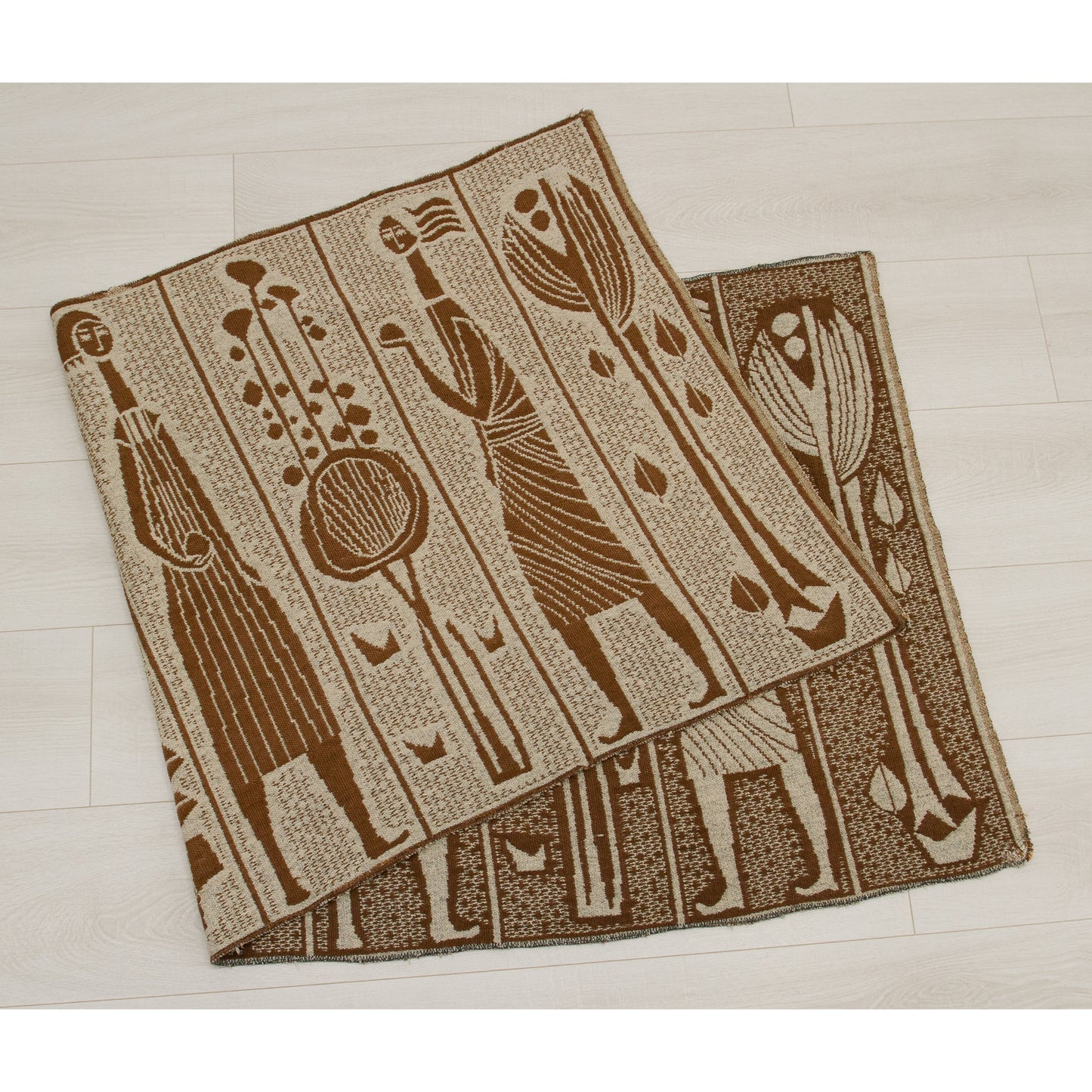 Folded vintage woven textile showing the reversible pattern. The underside features a darker charcoal geometric design, suitable for use as a table runner or wall hanging.