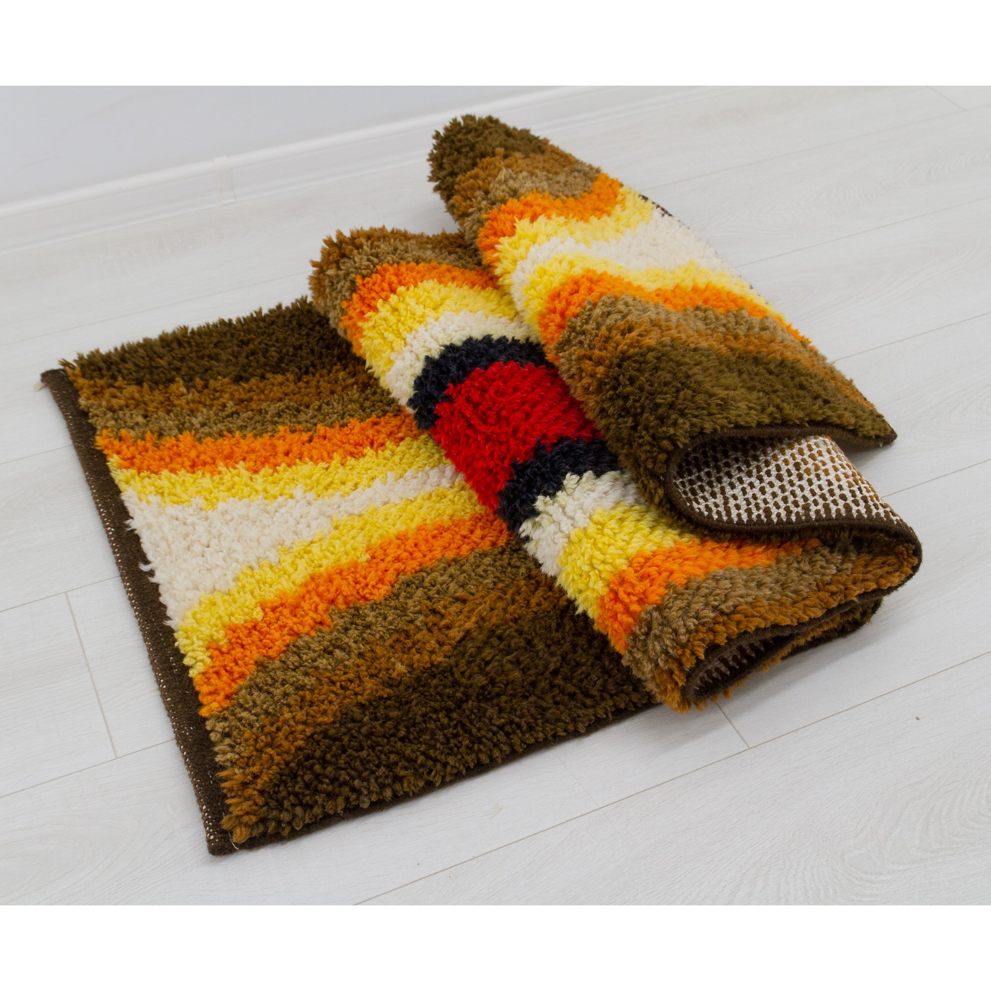 Tightly rolled thick vintage shag carpet wall art exhibiting deep chocolate and golden retro colors. Soft and pileable rug with strong and sturdy woven foundation.