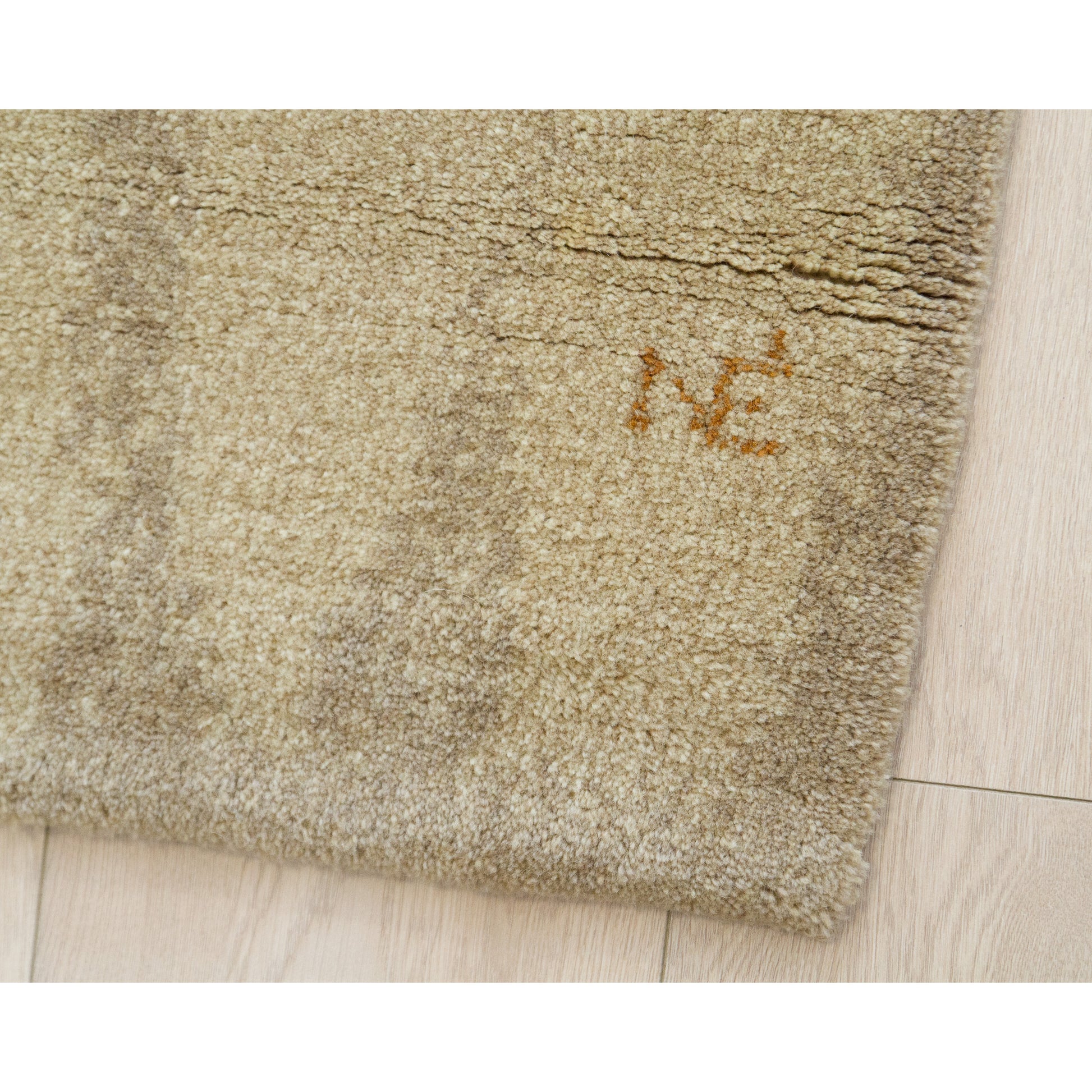 Close up of the authentic "NE" artist signature hand-knotted into the corner of the heavy wool tapestry. A verifiable, rare collector's gem by designer Eva Nemeth.