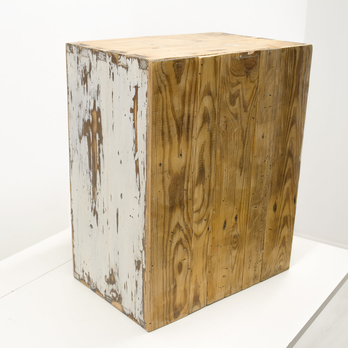 Small vintage wall cabinet in a rustic farmhouse style, with a weathered but expertly refinished surface, featuring a natural brown wood grain front and sides with peeling white paint on the left side, set against a plain white background.