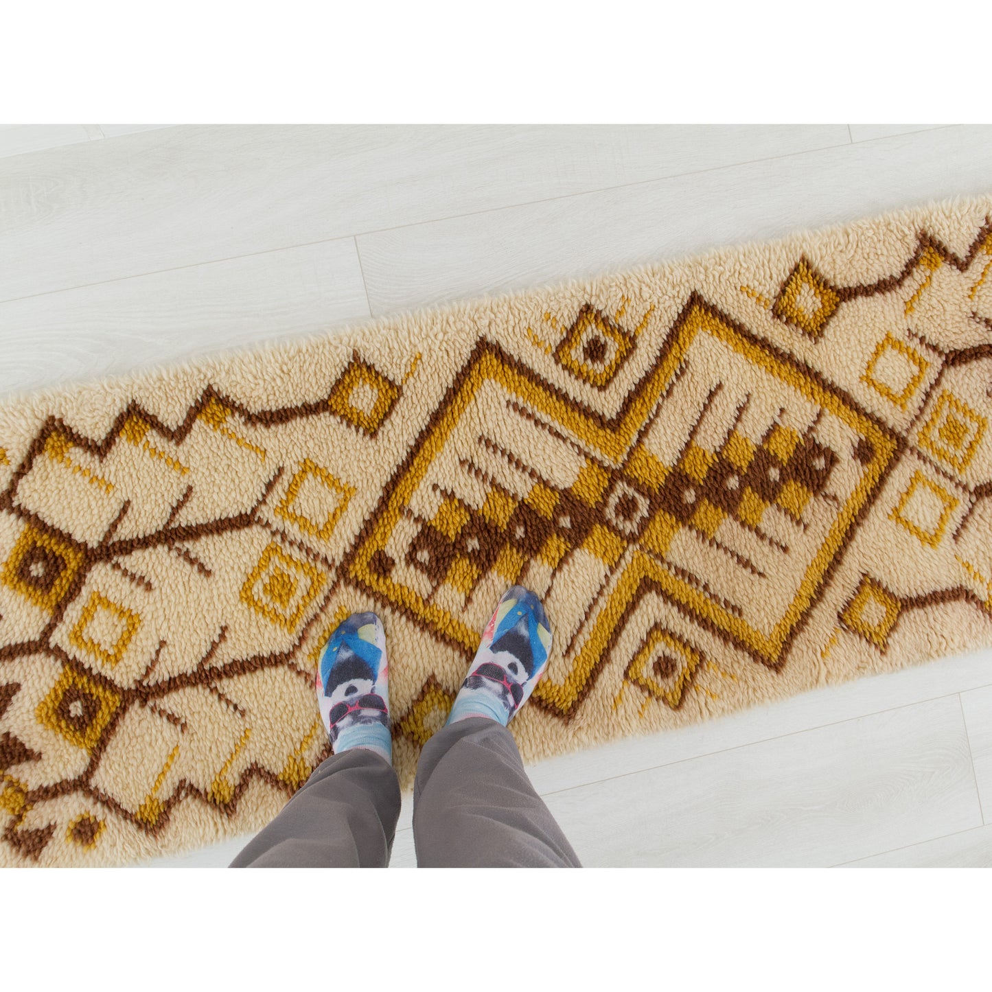 Point of view photography of a person standing playfully on the soft 1970s long hallway floor runner rug, perfectly indicating scale and domestic use.