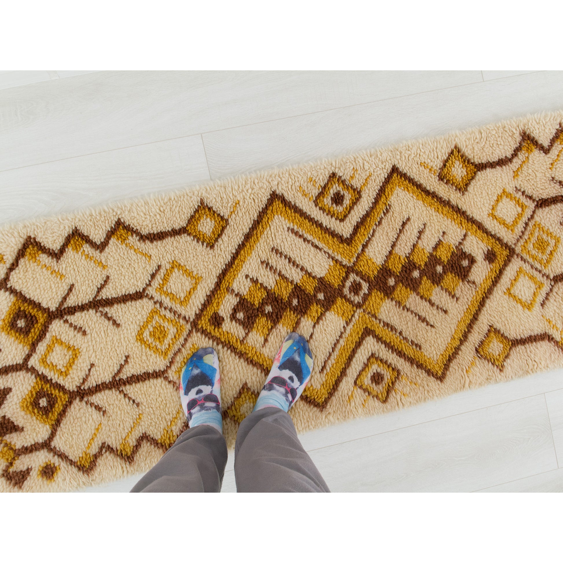 Point of view photography of a person standing playfully on the soft 1970s long hallway floor runner rug, perfectly indicating scale and domestic use.
