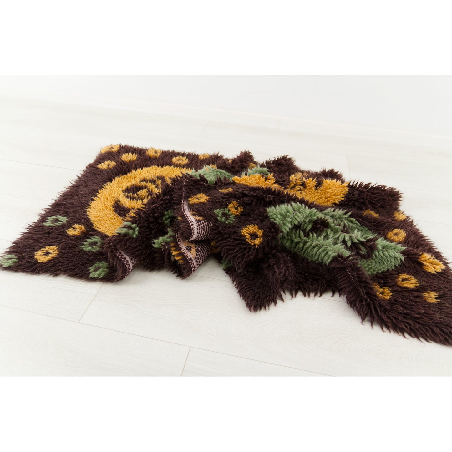 The soft cotton-blend tapestry artfully draped upon a floor, demonstrating how flexible and cozy it behaves when styled as an end-of-bed or armchair throw.