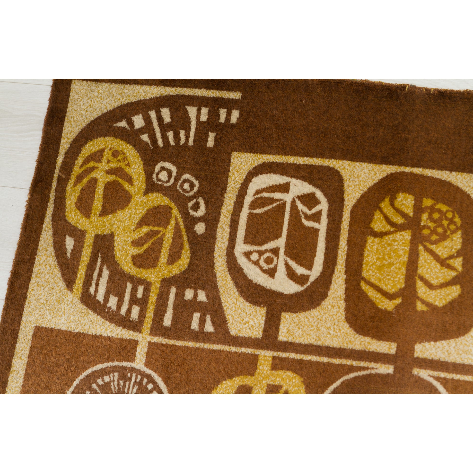 Macro detail of the moquette texture. Shows the fuzzy, soft pile of the fabric featuring geometric leaf patterns inside organic tree shapes. Warm, cozy vintage home decor.