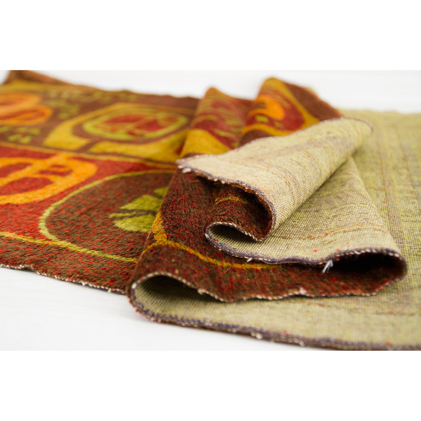 Macro perspective focusing deep into the draped folds of the moquette tapestry, illustrating its supreme coziness and thick textural presence.
