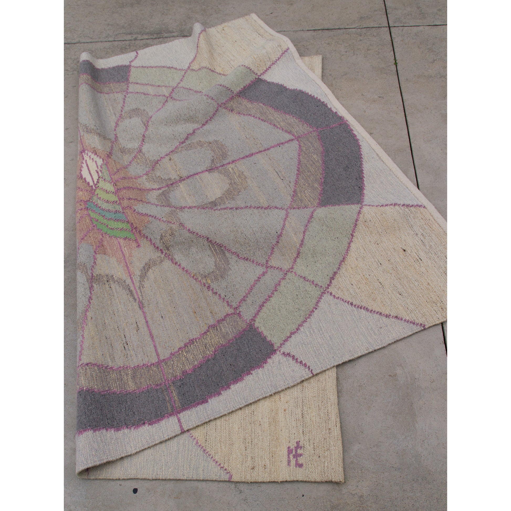 The geometric tapestry folded across itself on the floor, validating that the pattern translates perfectly to the immaculately clean backside.