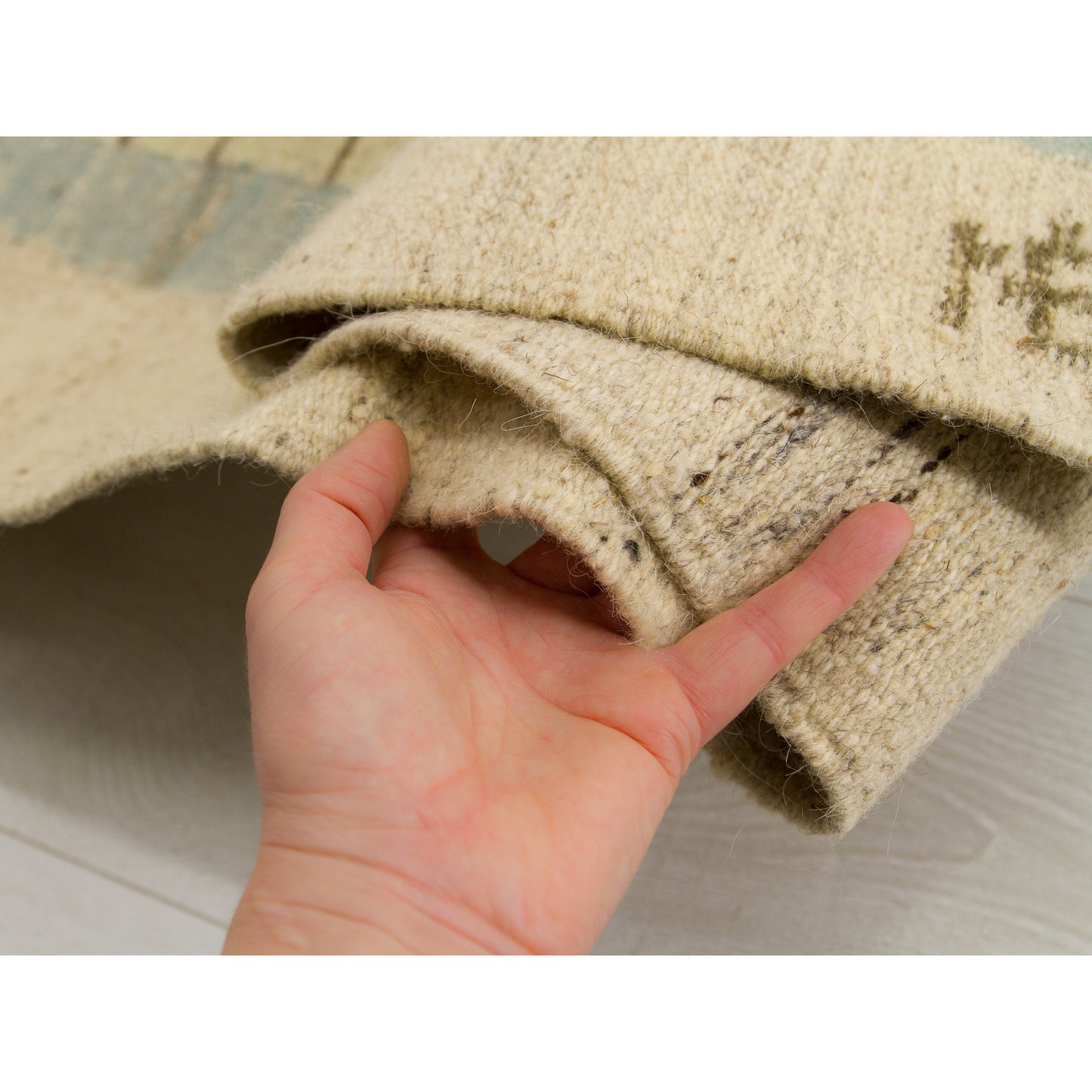 A hand touching the thick, study woven wool fabric of the vintage textile, demonstrating the premium feel and durability of this collector's masterpiece.