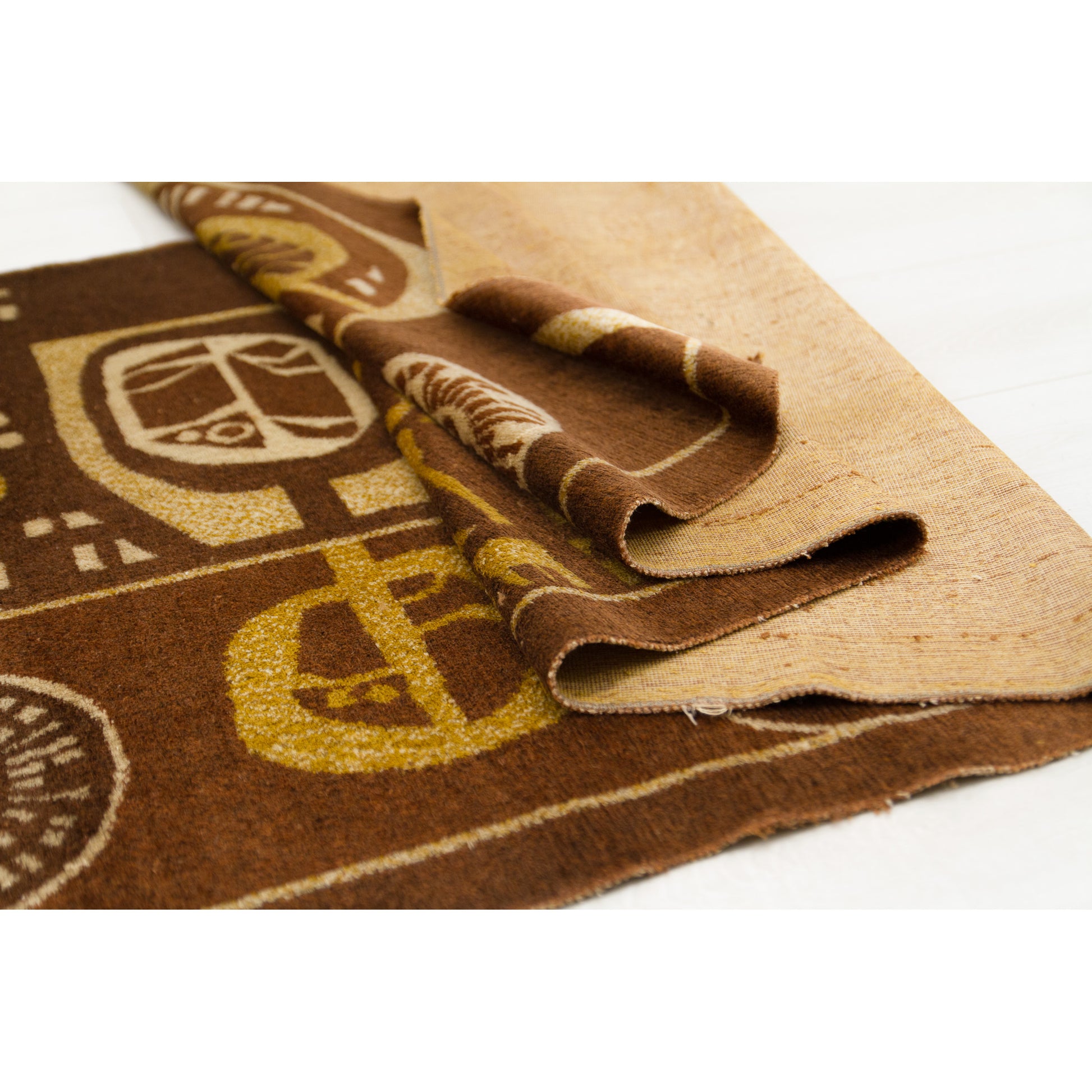 Vintage 1960s textile art folded to demonstrate the pliable, soft nature of the wool-blend moquette fabric. The rich chocolate brown and harvest gold velvet pile contrasts with the clean, sturdy woven backing.