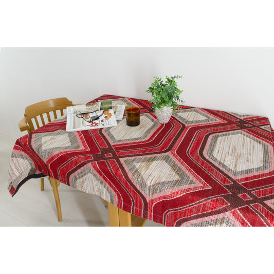 Vintage 70s red geometric woven fabric used as a tablecloth on a wooden dining table
