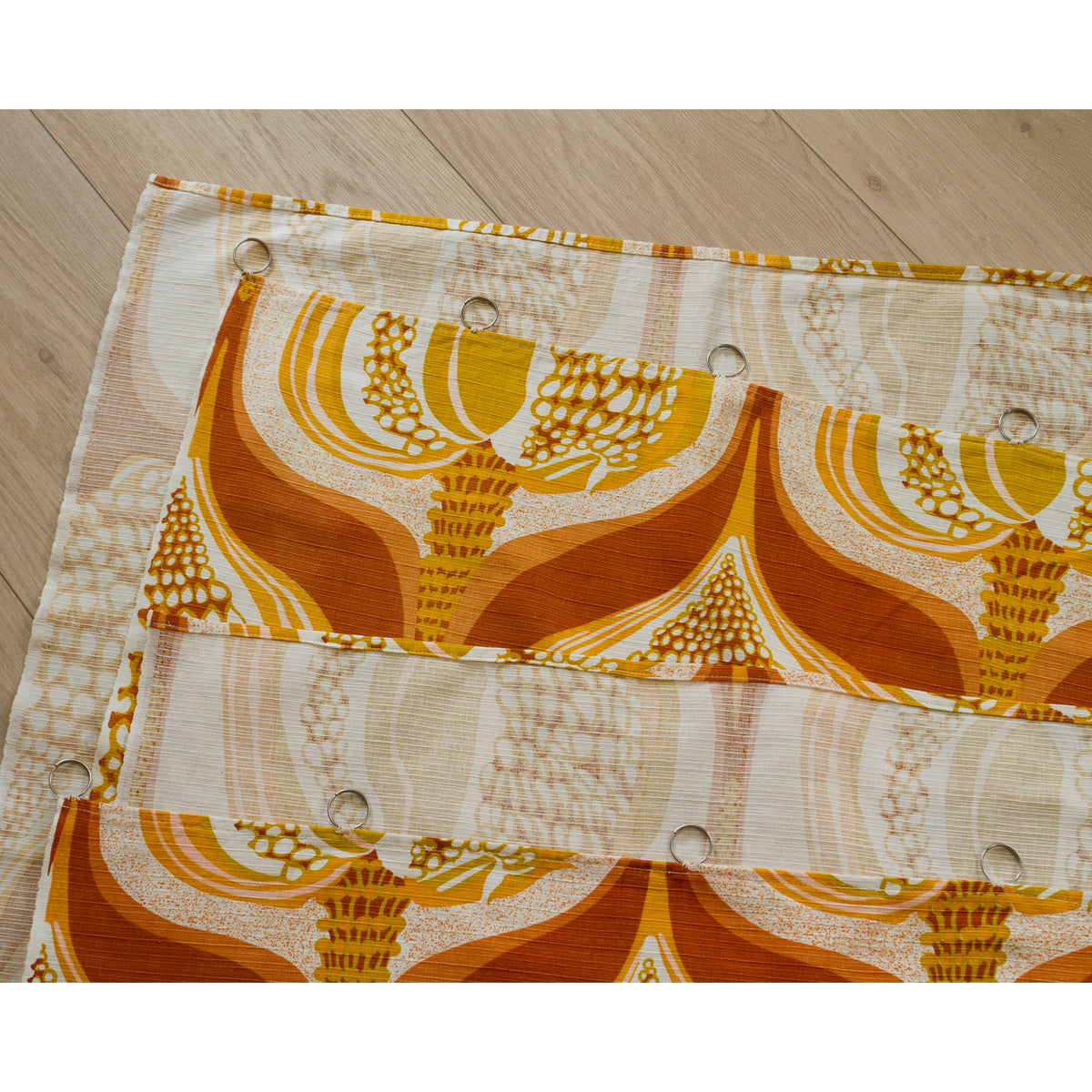 Top edge of vintage curtain panel with sewn-on metal rings for hanging on a rod