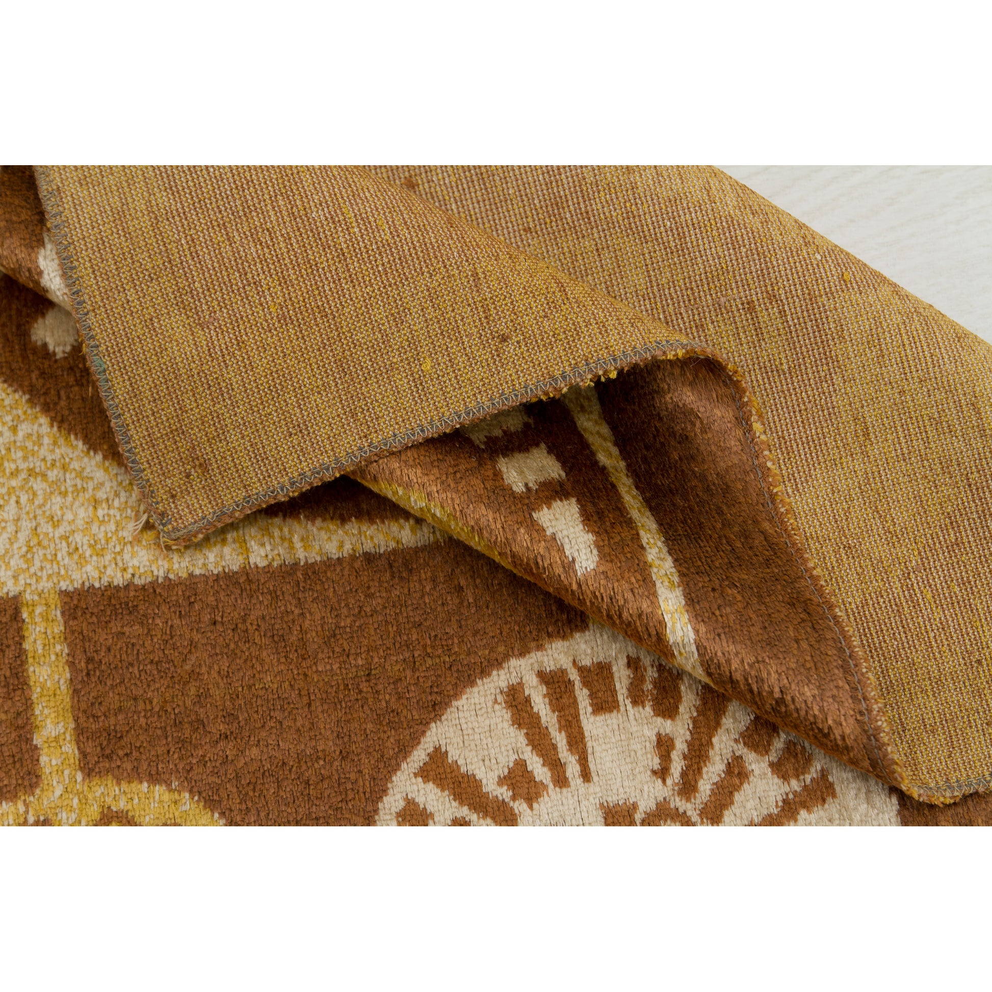 Macro view of the corner fold, showing the raw serged edge and the tightly woven textile backing. Authentic vintage construction without rubber or glue layers.