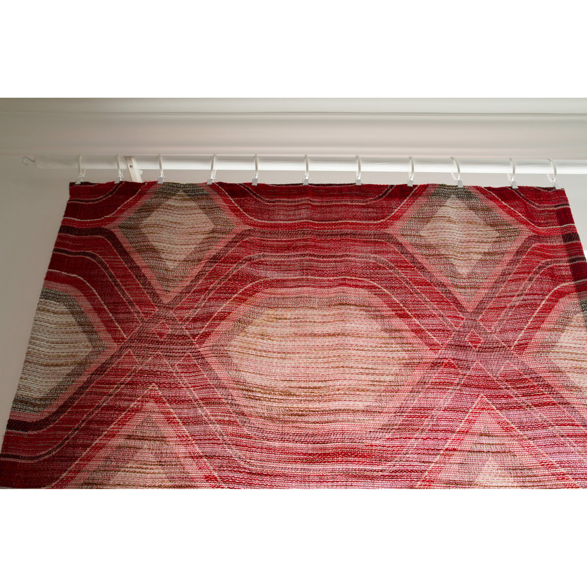 Vintage op art fabric panel hung across its full width, showing the large hexagon pattern and mounting