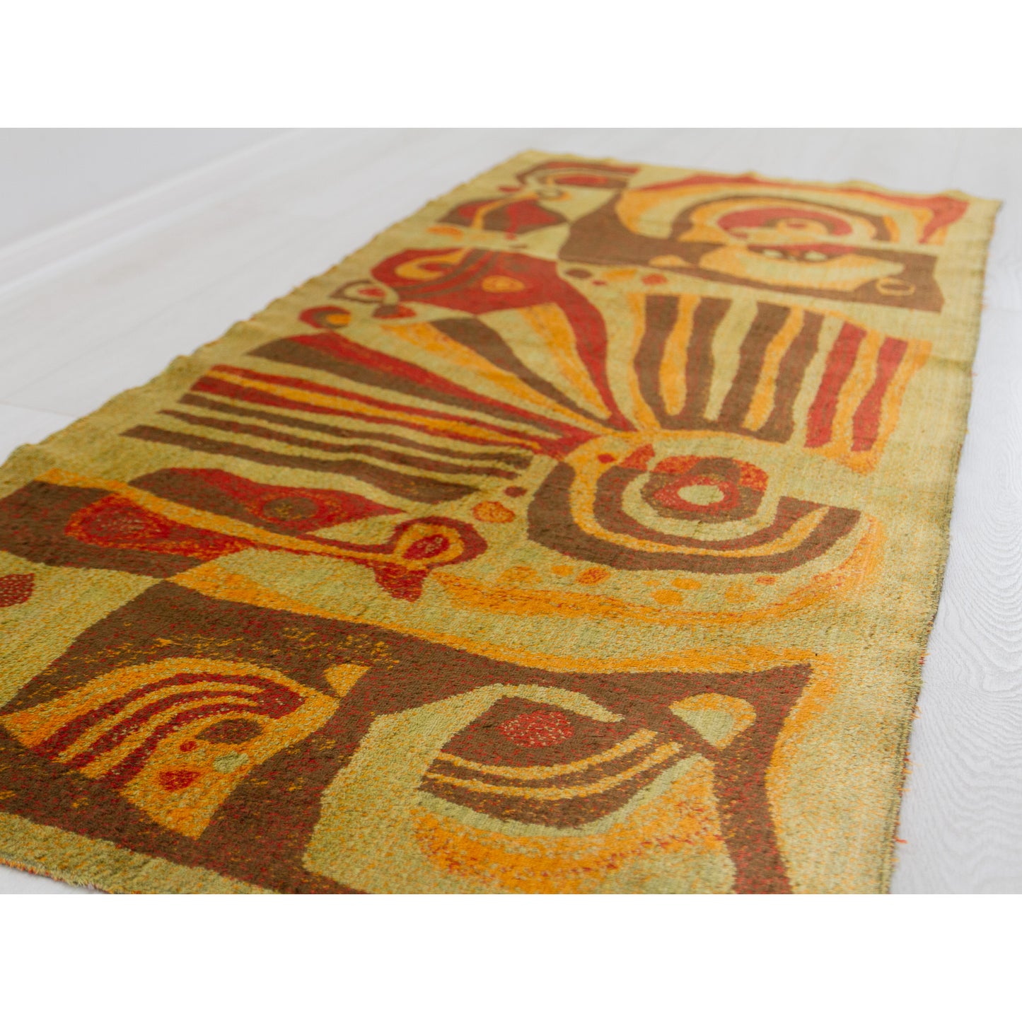 Low angle view of the tapestry showing the abstract abudance of organic - geometric motives and the warm lime-orange color scheme typical of the mid century era.