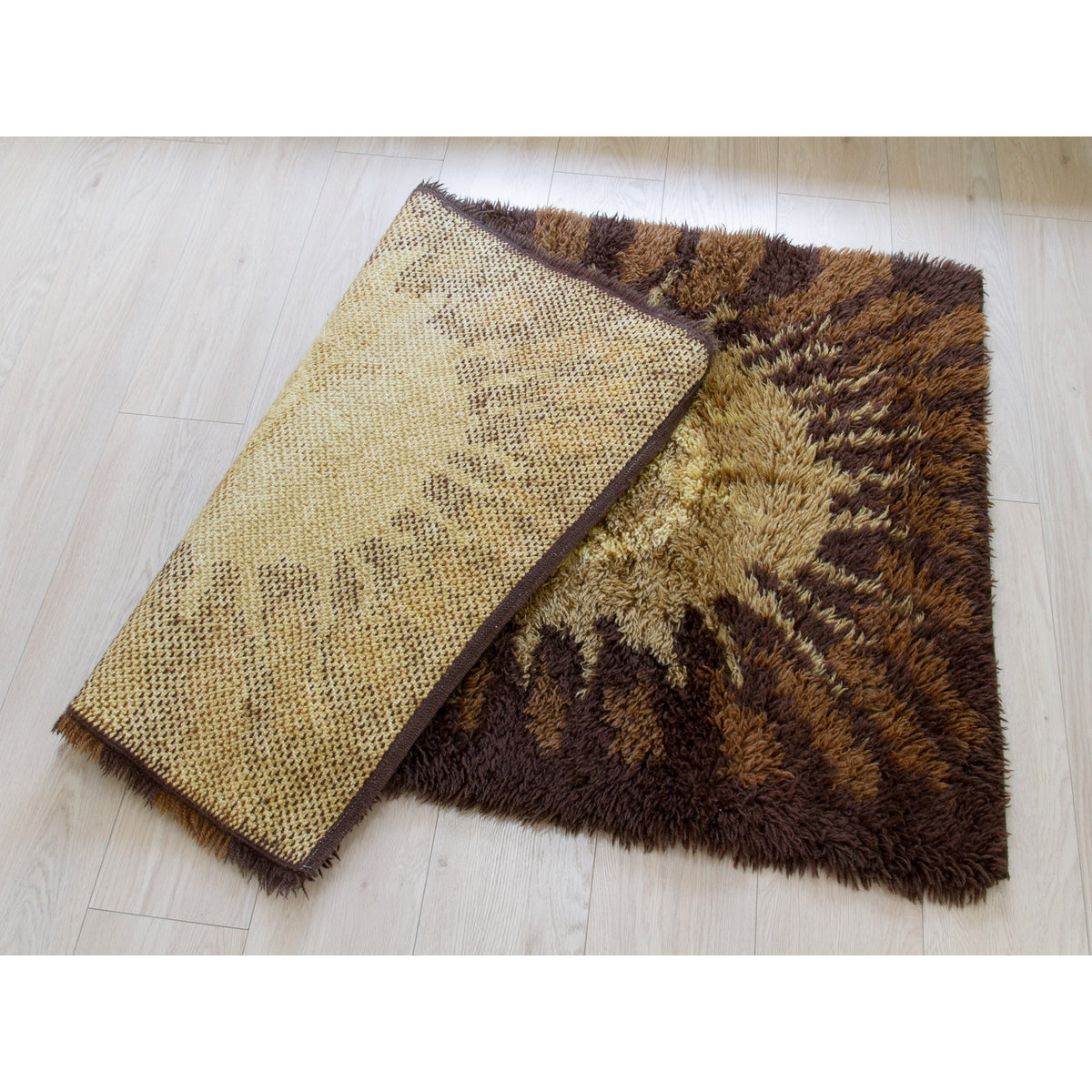 Small vintage rya rug folded to show the clean and damage-free backing and overall great condition