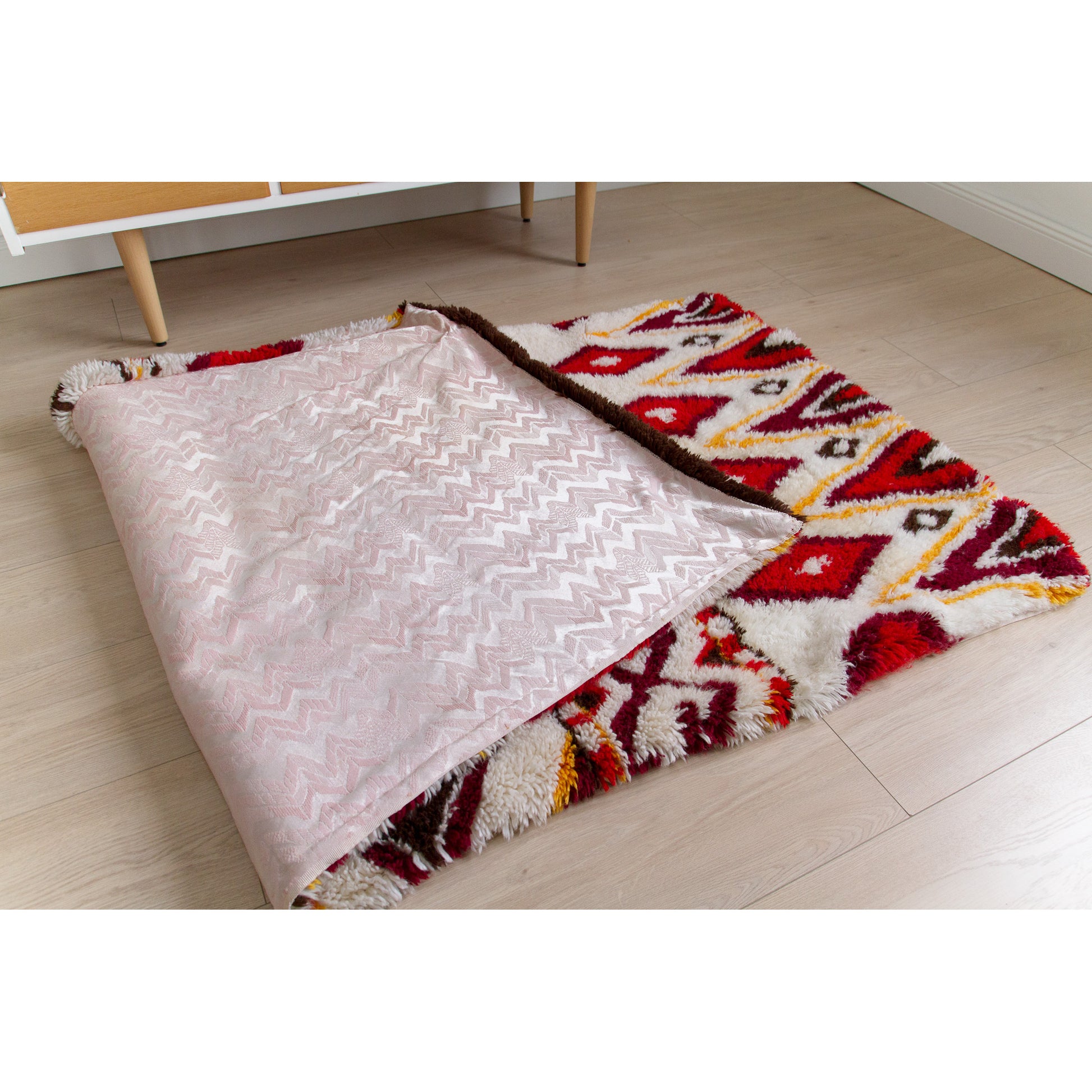 The massive 72-inch vintage tapestry laid on the floor and folded halfway back to reveal its secret detail: a highly durable, beautifully preserved pale pink cotton fabric lining.
