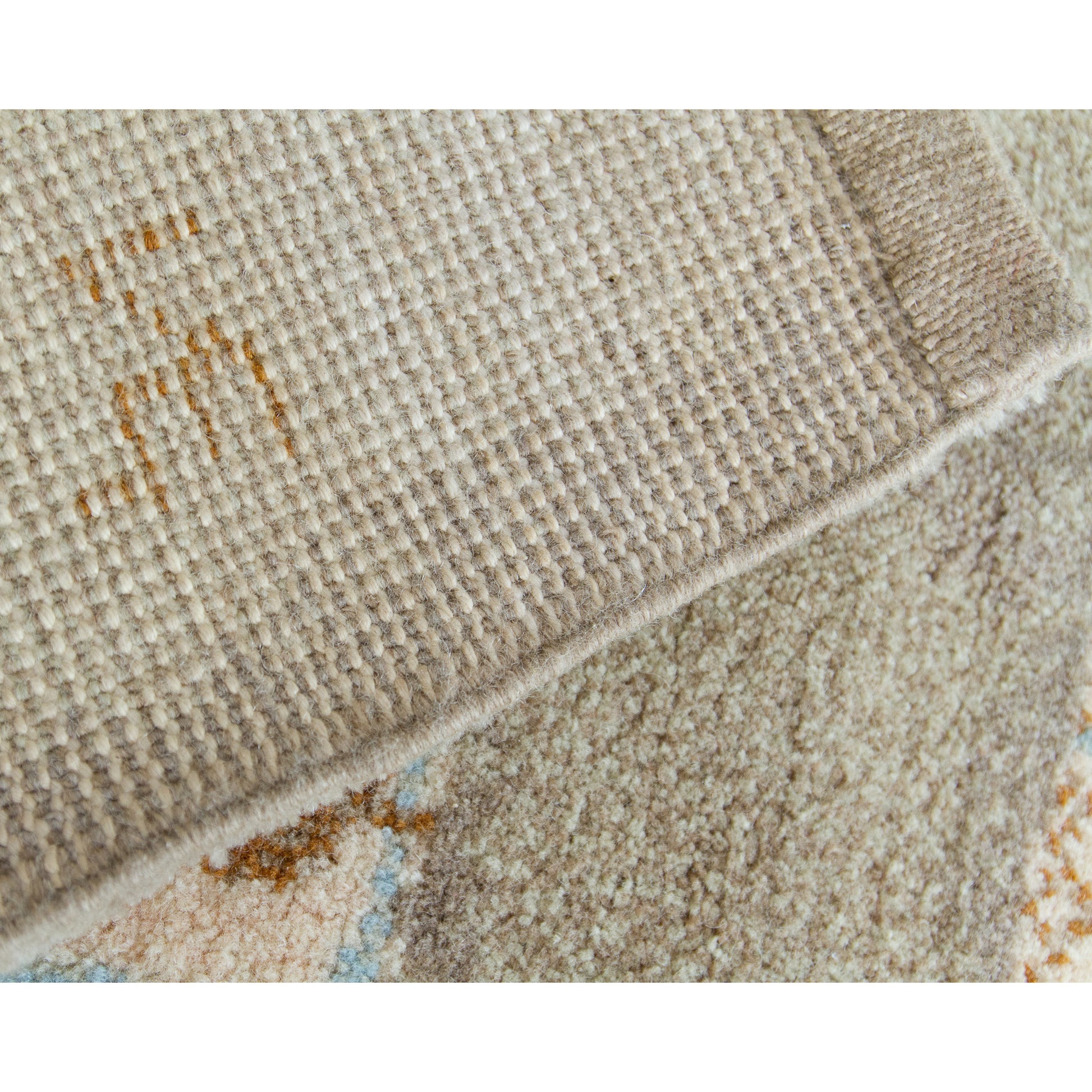 The mid-century modern rug folded over to expose the meticulously crafted reverse side. Displays the millions of individual fine wool knots on a sturdy cotton foundation. The artist's signature - NE monogram - is thightly knotted into the rug.