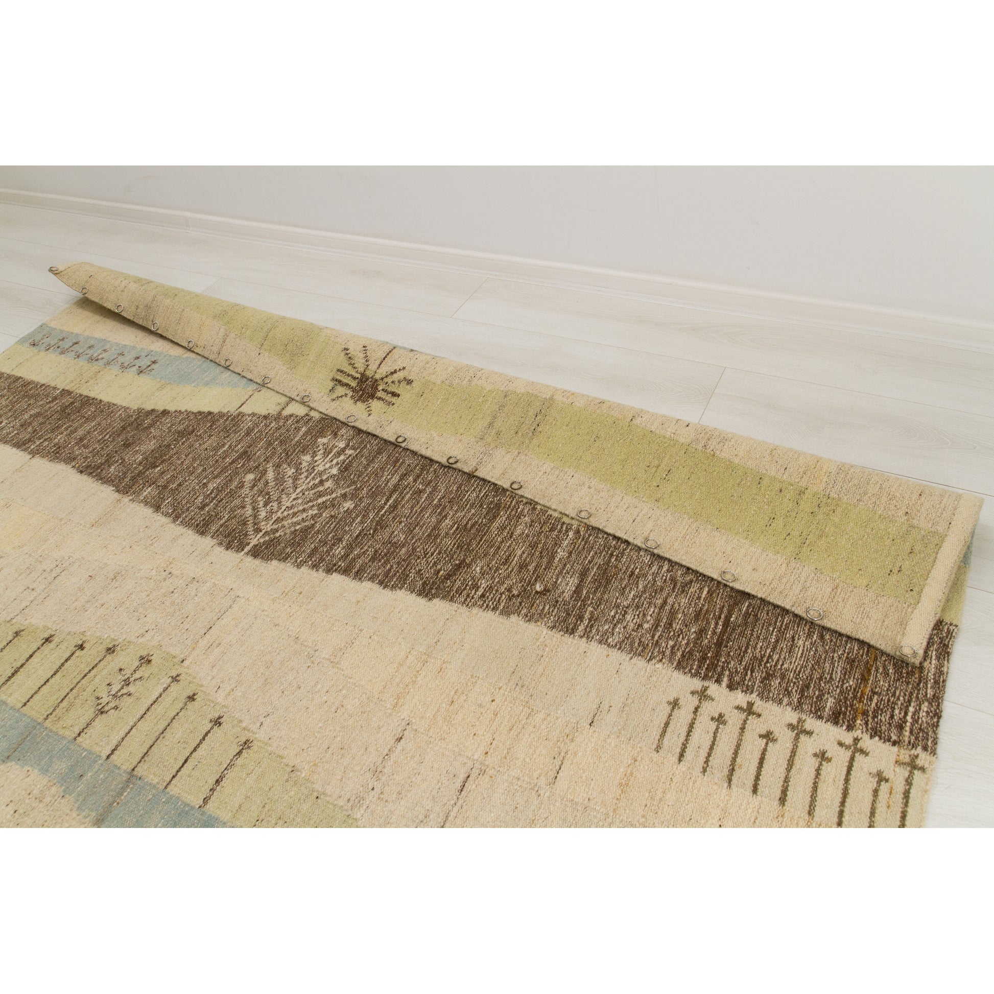 The rear view of the top binding edge on the handwoven rug, showing small rings perfectly spaced for supporting this monumental piece of mid-century wall art.