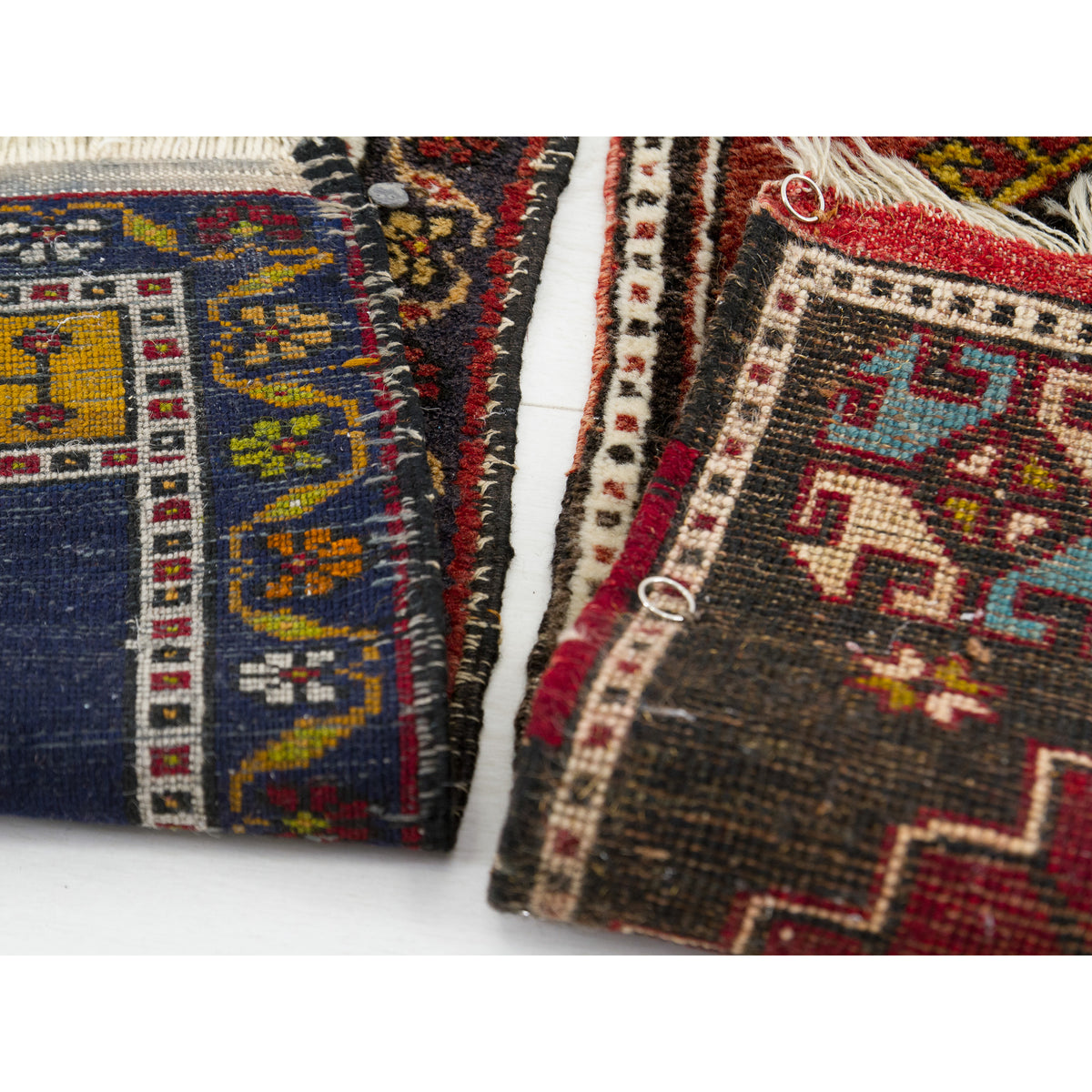 Edges of two vintage yastik rugs showing handmade irregularities and antique patina