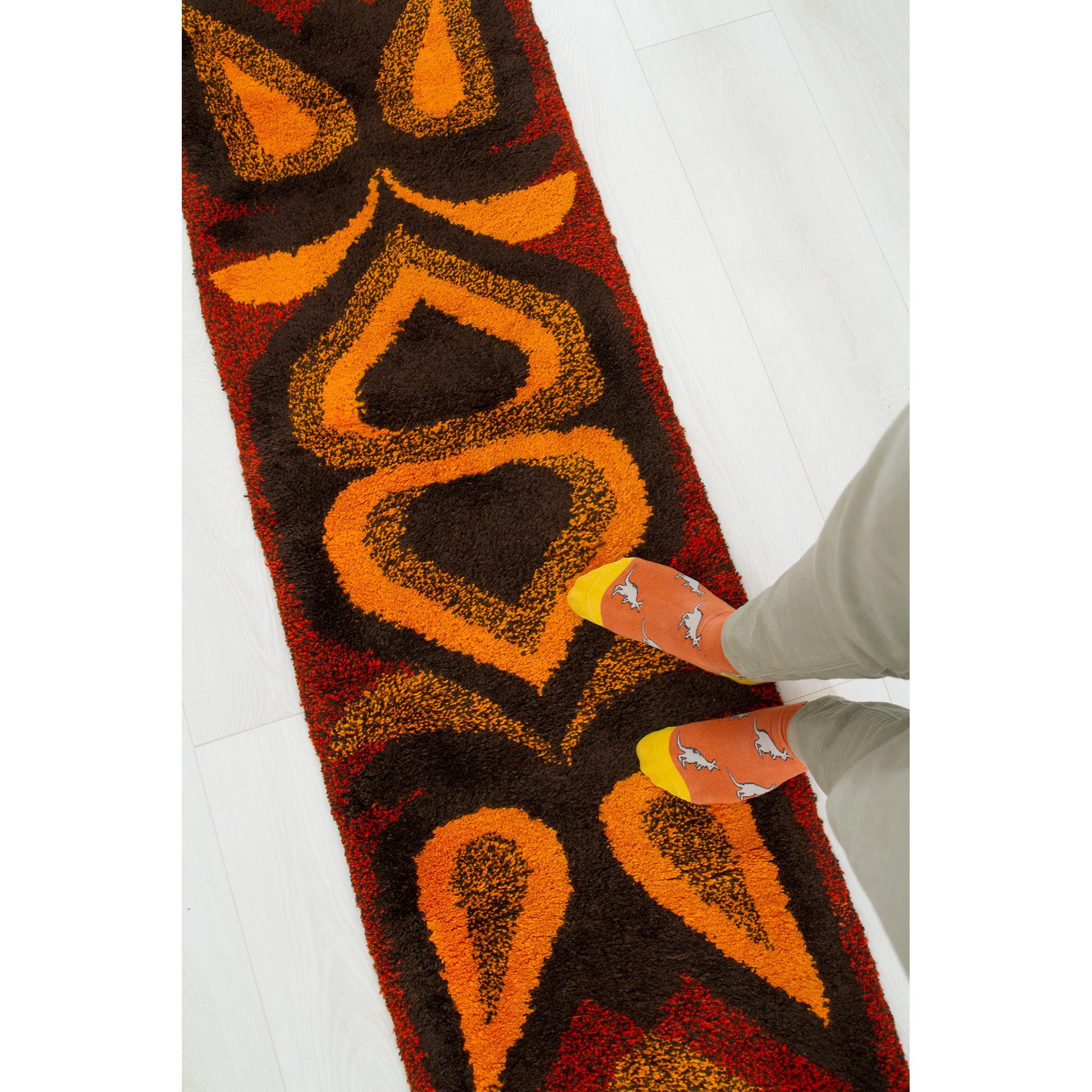 Photographer's feet standing directly on the vibrant 68-inch long runner rug to display scale, signaling its brilliant potential as cozy boho floor decor.